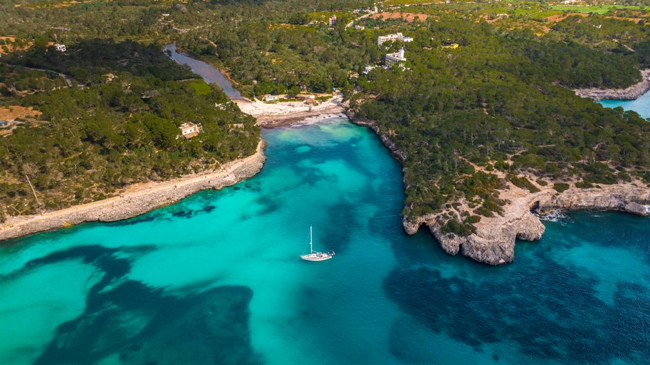 Explore the stunning turquoise waters and dramatic cliffs of Mallorca's Balearic coast from above.